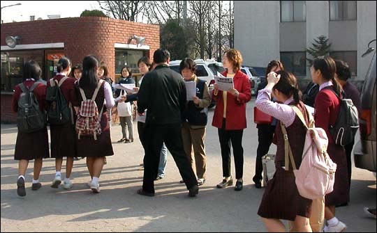 Y여고 분회 교사들이 학생들에게 유인물을 나눠주고 있다 